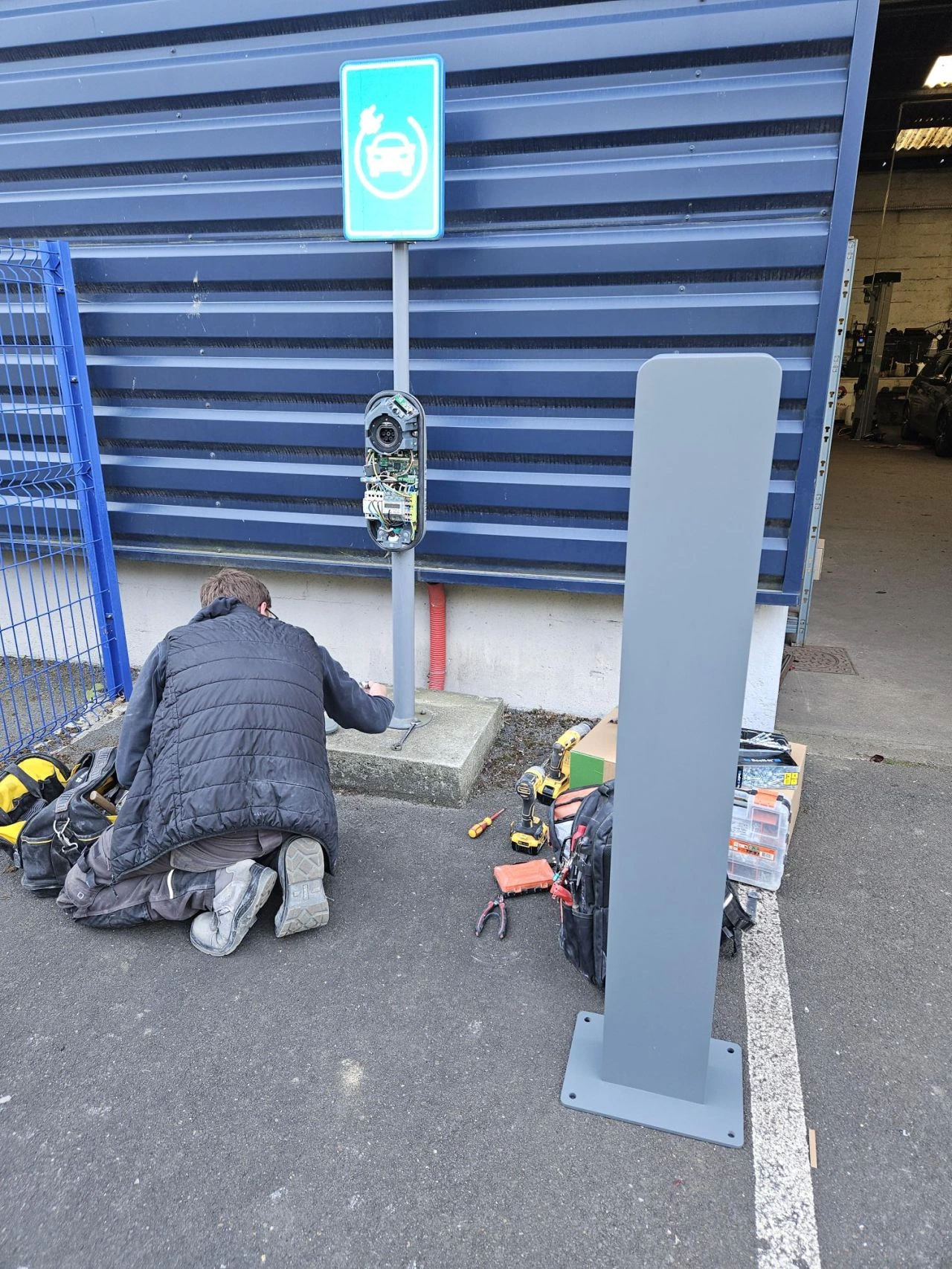 Technicien Voltec en cours de raccordement de la nouvelle borne de recharge